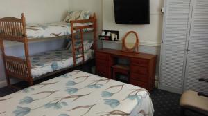 a bedroom with two bunk beds and a mirror at Havelock Guesthouse in Saint Helier Jersey