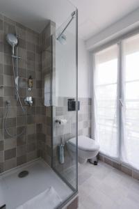 a bathroom with a shower and a toilet at Le Petit Cosy Hôtel in Paris