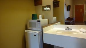 a bathroom with a sink and a microwave at La Copa Inn in McAllen