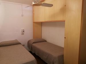 モンデッロにあるVilla Caterinaのベッド2台、天井ファンが備わる小さな客室です。