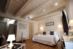 ein Schlafzimmer mit einem weißen Bett in einem Zimmer in der Unterkunft La Maison De Charme ROOMS in Verona
