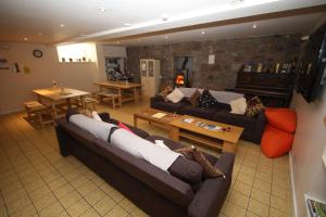 una sala de estar con 2 personas en sofás en Ballater Hostel, en Ballater