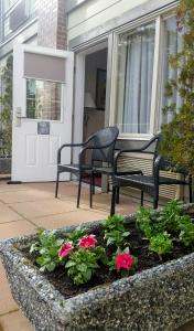 a porch with two chairs and a table and flowers at Holiday Inn Victoria - Elk Lake by IHG in Victoria