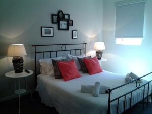 a bedroom with a bed with red pillows and two lamps at Guest House Antero de Quental in Porto