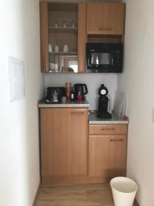 a small kitchen with wooden cabinets and a microwave at Bella Vita in Rust