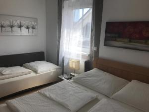 2 Betten in einem kleinen Zimmer mit Fenster in der Unterkunft Bella Vita in Rust