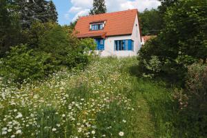 una casa con techo rojo y un campo de flores en Rekreační vilka Zlenice, en Zlenice 