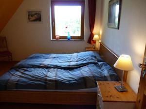 a bedroom with a bed with a window and a table at Haus-Marla in Tating