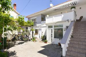 a white house with a patio and stairs at Apartment Vesna in Zadar