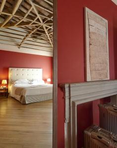 Hotel 500 Firenze في كامبي بيسينسيو: غرفة نوم بسرير وجدار احمر
