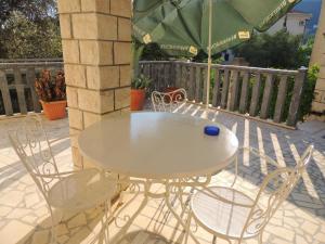einen Tisch und Stühle auf einer Terrasse mit Sonnenschirm in der Unterkunft Rooms Villa Desa in Budva