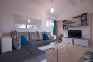 a living room with a couch and a tv at Apartments Kuljace in Sveti Stefan