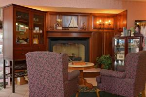 a living room filled with furniture and a fireplace at OurGuest Inn & Suites Downtown Port Clinton in Port Clinton