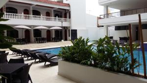 a hotel with a swimming pool and tables and chairs at Suite Sumapaz Hotel in Melgar