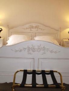 Una cama blanca con dos almohadas encima. en Les Rainettes en Coye-la-Forêt