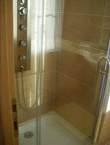 a shower with a glass door in a bathroom at Les Rainettes in Coye-la-Forêt