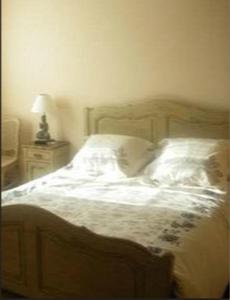 a bedroom with a bed with white sheets and pillows at Les Rainettes in Coye-la-Forêt