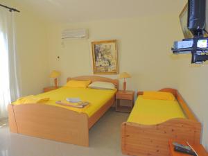 2 Einzelbetten in einem Zimmer mit gelber Bettwäsche in der Unterkunft Rooms Villa Desa in Budva