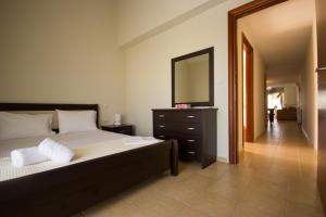 ケラモティにあるAngel Luxury Apartmentsのベッドルーム1室(ドレッサー付きベッド1台、鏡付)