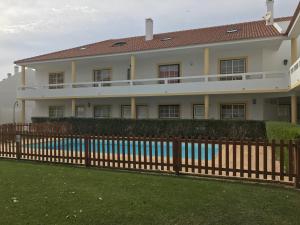 a house with a fence in front of it at Casa do Baleal in Baleal