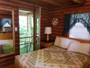 1 dormitorio con 1 cama en una cabaña de madera en Seven Dwarfs Cabin - On The Brook Cabins, en Lake George