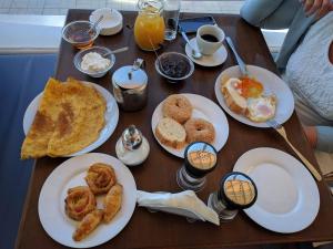 uma mesa de madeira com pratos de comida para o pequeno-almoço em Blue Nest Hotel em Tigaki
