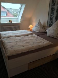 ビューズムにあるHaus-Norderpiepの窓付きの小さな部屋のベッド1台分です。