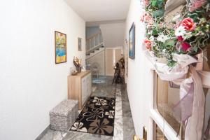 un couloir avec des fleurs et des plantes sur le mur dans l'établissement Villa Rosa, à Brodarica