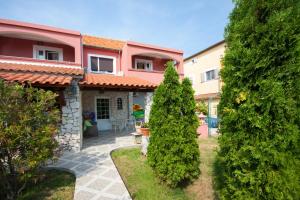 a house with a yard with two trees at Villa Rosa in Brodarica