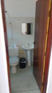 a bathroom with a toilet and a sink at Pousada Nova Opção in Bertioga