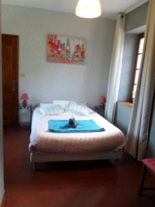 a bedroom with a bed with a cat laying on it at Auberge a la Ferme in Surques