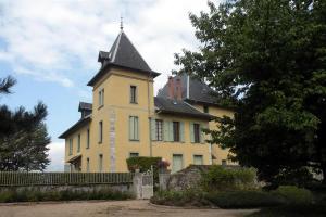 uma grande casa amarela com uma torre em cima dela em Chateau du Donjon em Drumettaz-Clarafond