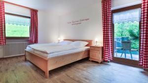 ビショフスヴィーゼンにあるFerienwohnung Wiesenlehenのベッドルーム1室(ベッド1台、大きな窓付)