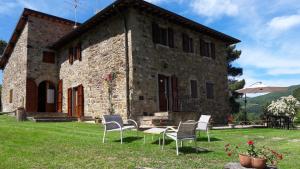 a stone house with chairs in front of it at Casolare Giovangrande in Poppi