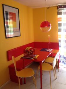 a dining room with a red table and chairs at Direkt am Main in Karlstadt