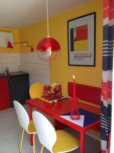 a dining room with a red table and chairs with a candle at Direkt am Main in Karlstadt