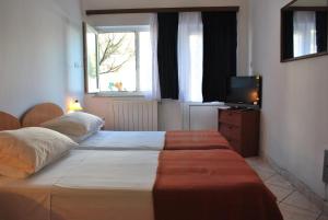 a bedroom with two beds and a television in it at Apartment Dragun in Pula