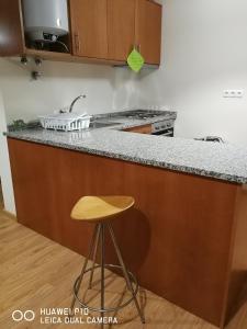 uma cozinha com um balcão com um banco e um lavatório em Casas Marias de Portugal - Cerveira em Vila Nova de Cerveira