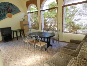 a dining room with a table and chairs and a tv at Dom on the seaside in Zatoka