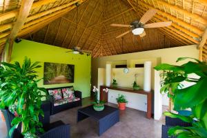 Fiesta Resort All Inclusive Central Pacific - Costa Rica في El Roble: غرفة معيشة مع مروحة سقف ونباتات