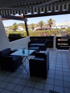 un patio con mesas, sillas y palmeras en Port nature, en Cap d'Agde