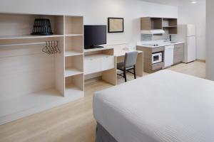 Habitación con cama y escritorio con TV. en WoodSpring Suites Seattle Everett, en Everett