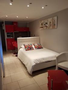 sypialnia z białym łóżkiem i czerwonymi szafkami w obiekcie Port nature w Cap d'Agde