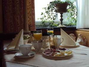 a table with a plate of food and a glass of orange juice at Bergheim in Pertisau