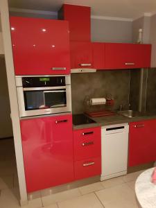 a red kitchen with red cabinets and a microwave at Port nature in Cap d'Agde