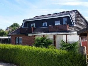 una casa con techo de gambrel y balcón en Haus Lily Nr.02 bis zu 6 Personen davon max. 2 Kinder, en Büsum