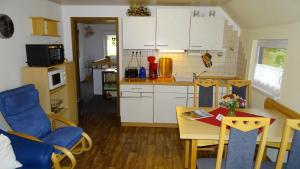uma pequena cozinha com uma mesa e uma sala de jantar em Ferienwohnung-Wasserlaeufer em Mulde