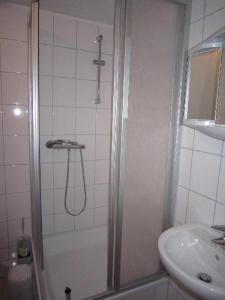 ein Bad mit einer Dusche und einem Waschbecken in der Unterkunft Ferienhäuser MoJe 1 in Dornum