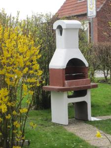 a brick oven sitting in the grass in a yard at Ferienhaeuser-MoJe-1 in Dornum