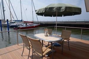 einen Tisch und Stühle mit einer Katze auf einem Boot in der Unterkunft "Hiddensee" in Wiek auf Rügen 